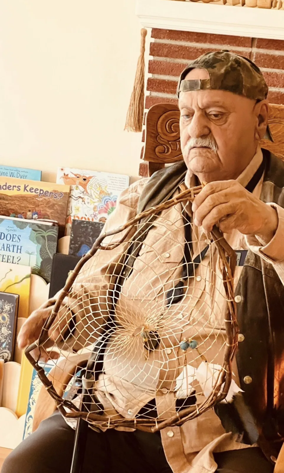 A visiting elder weaving a dreamcatcher by hand