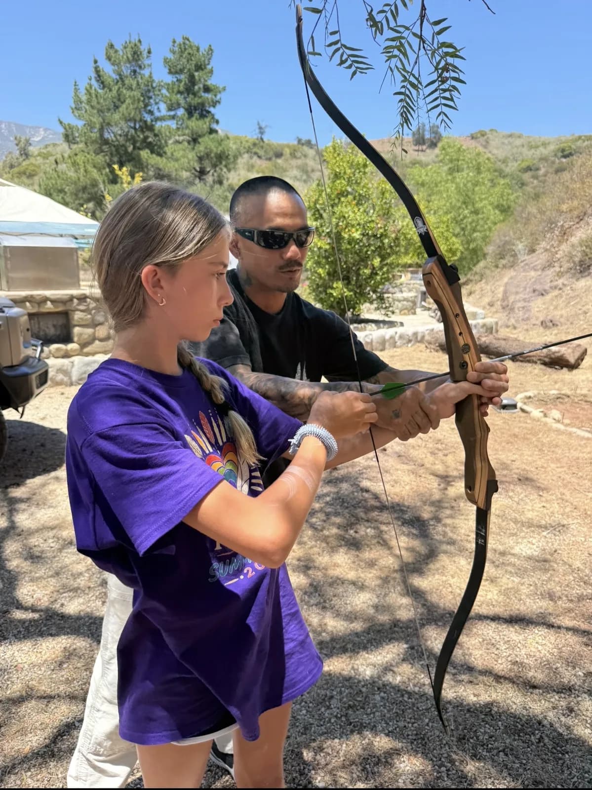 A child practicing steady attention while aiming a bow