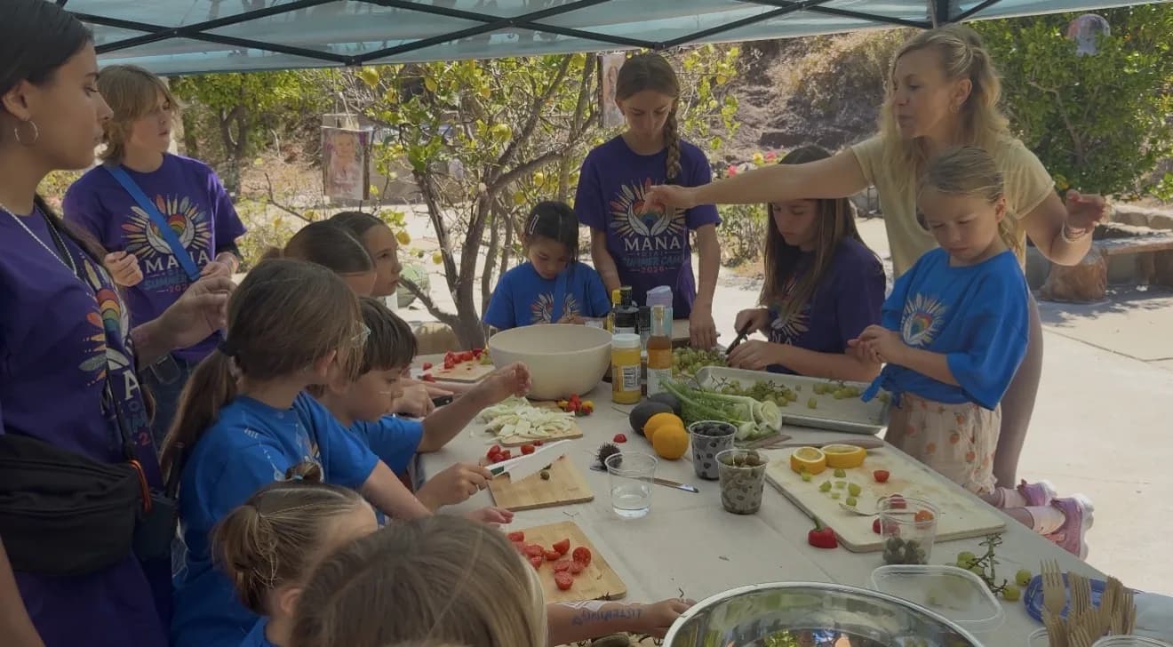 Children collaborating carefully as they prepare fruits and vegetables