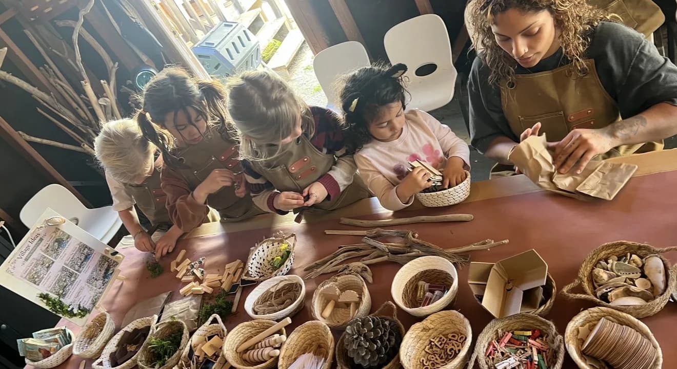 Children gathered around a table filled with baskets of natural materials