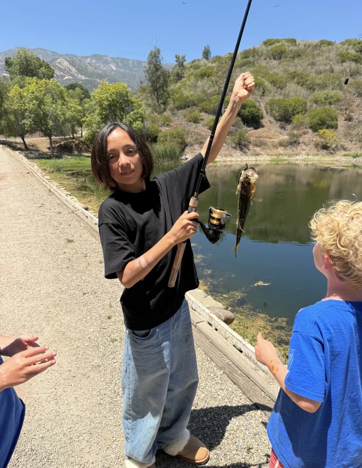 A child proudly sharing a fish during a pond investigation